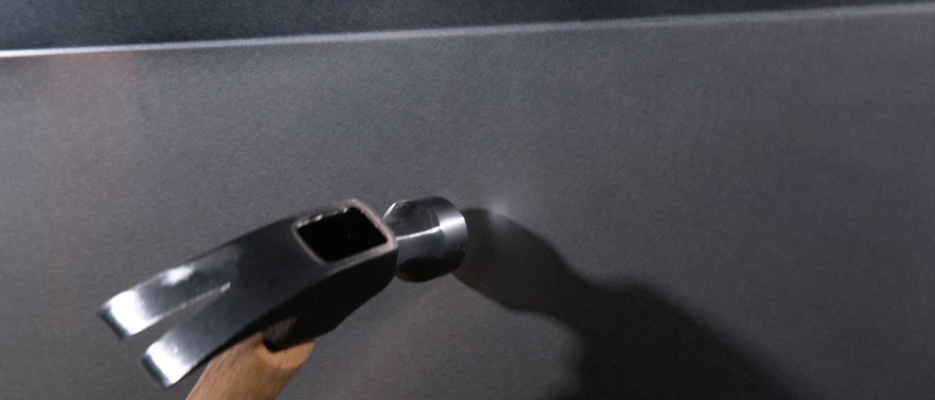 Tesla Cybertruck steel panel shrugging off a hammer blow