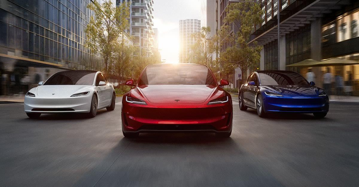 Tesla Model 3 lineup — white, red and blue sedans on a city street