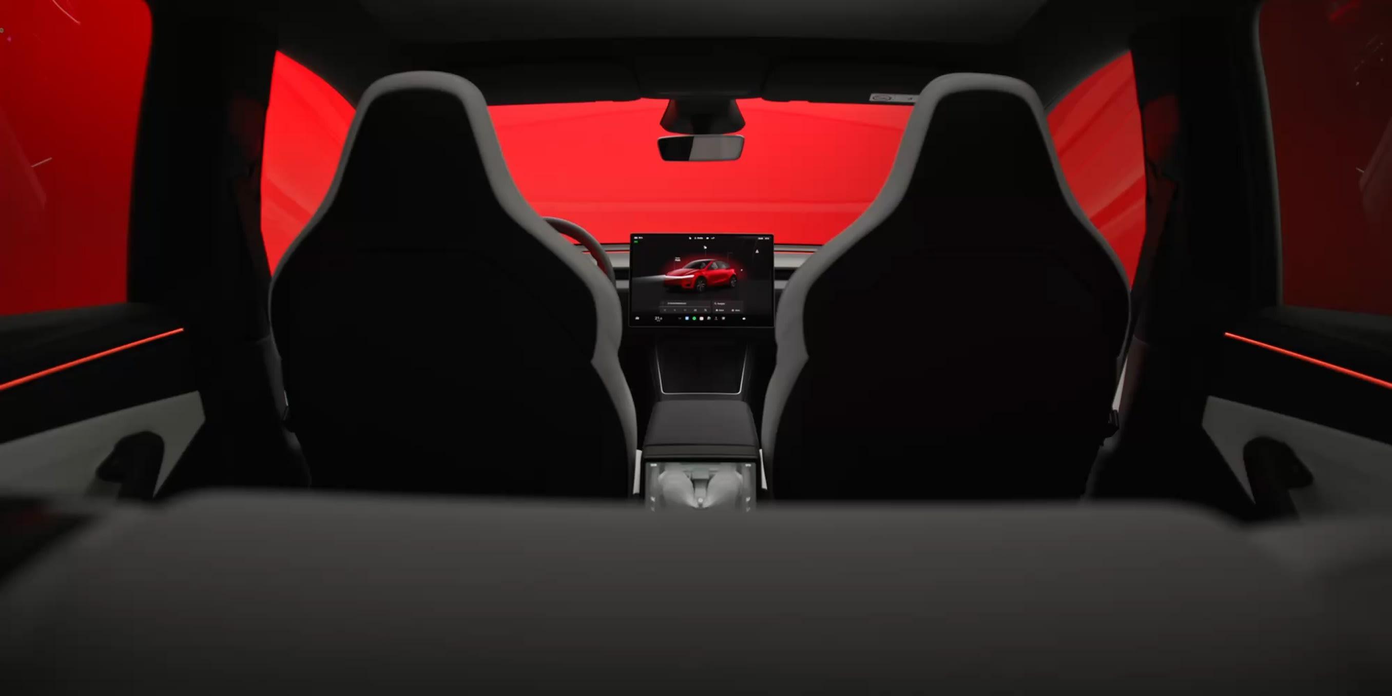 Model Y cabin from the rear seat. With no driver aboard, the centre screen and your phone are the entire interface.